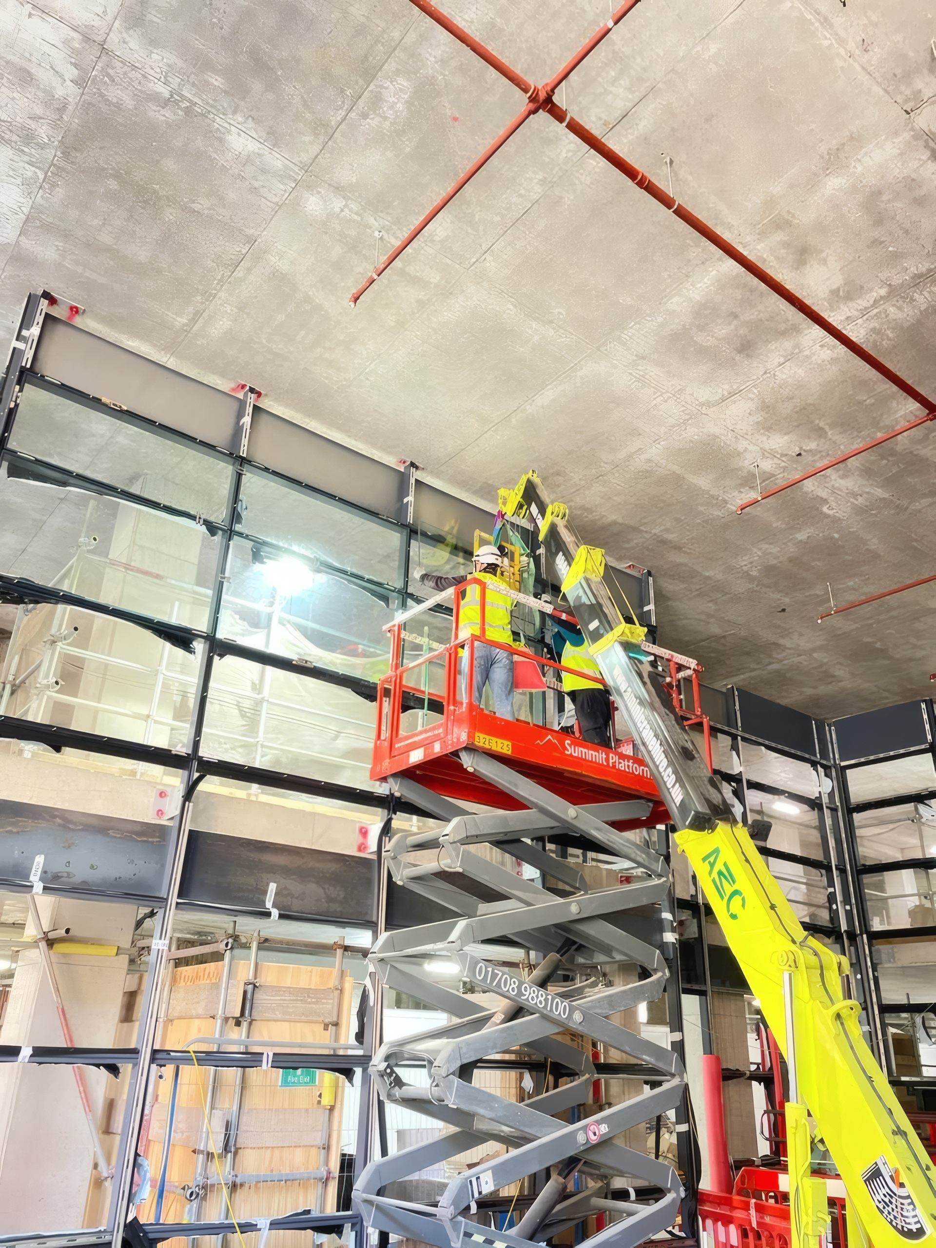 A steel member positioned with a spider crane and mobile access platform.