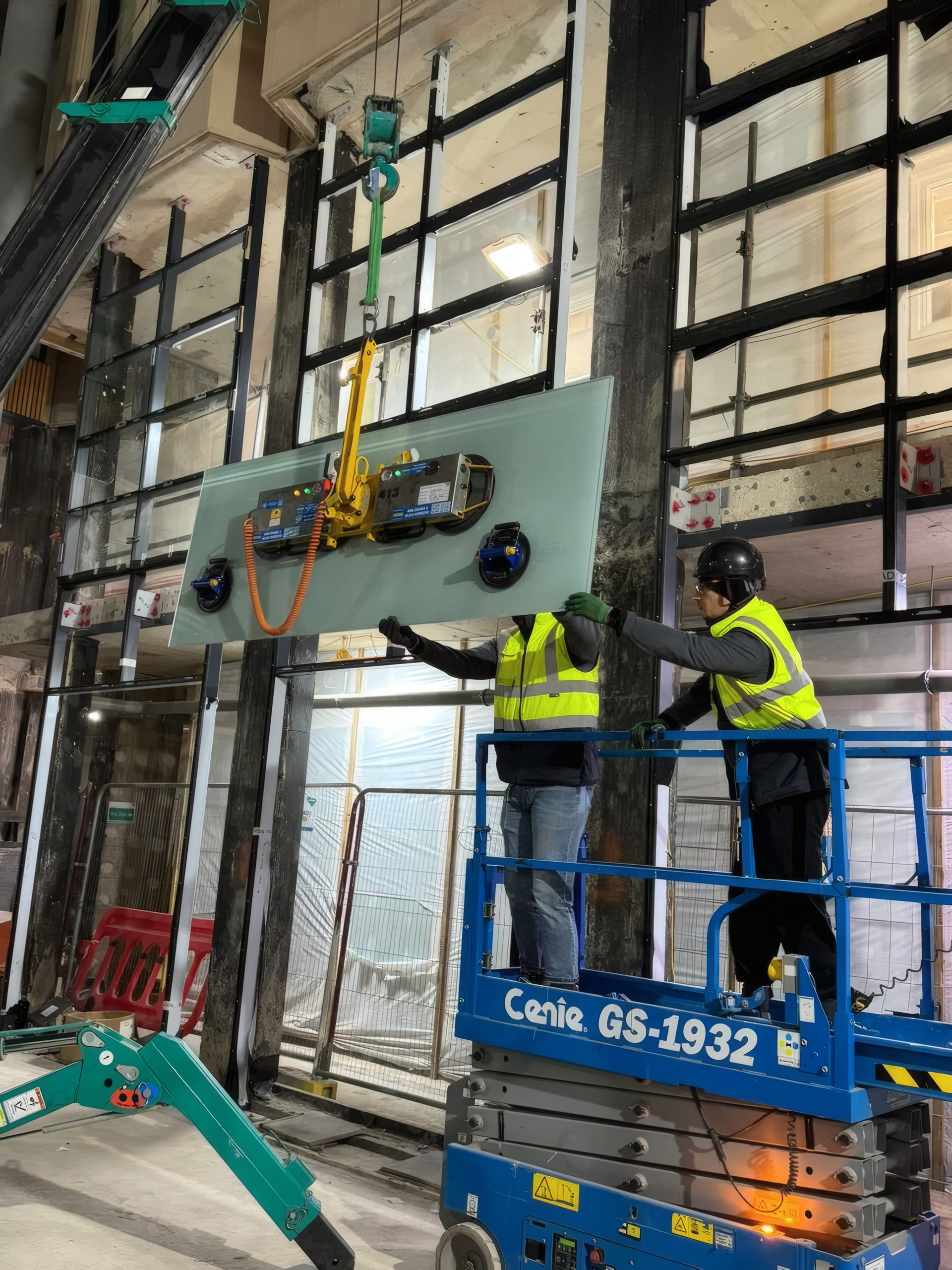 A glazing unit lifted into the facade frame on a vacuum lifter.
