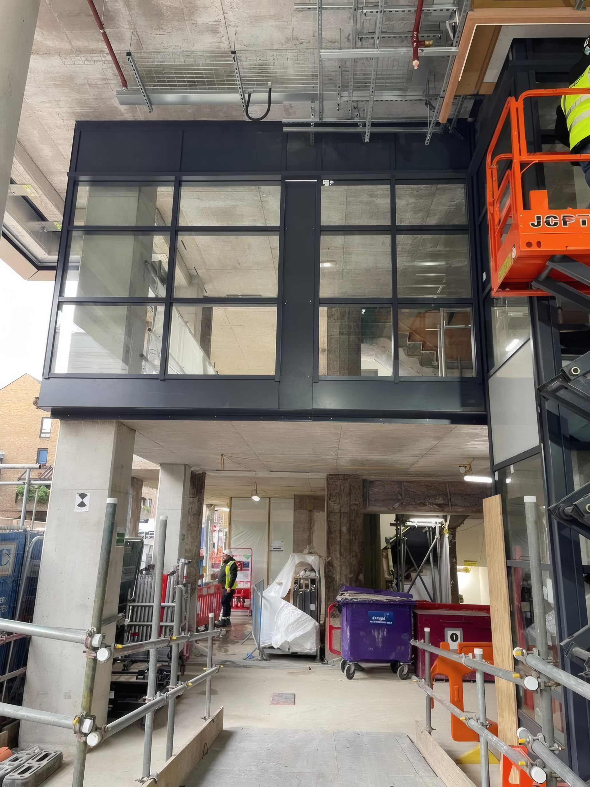 Glazing units installed to the upper facade from access platforms.