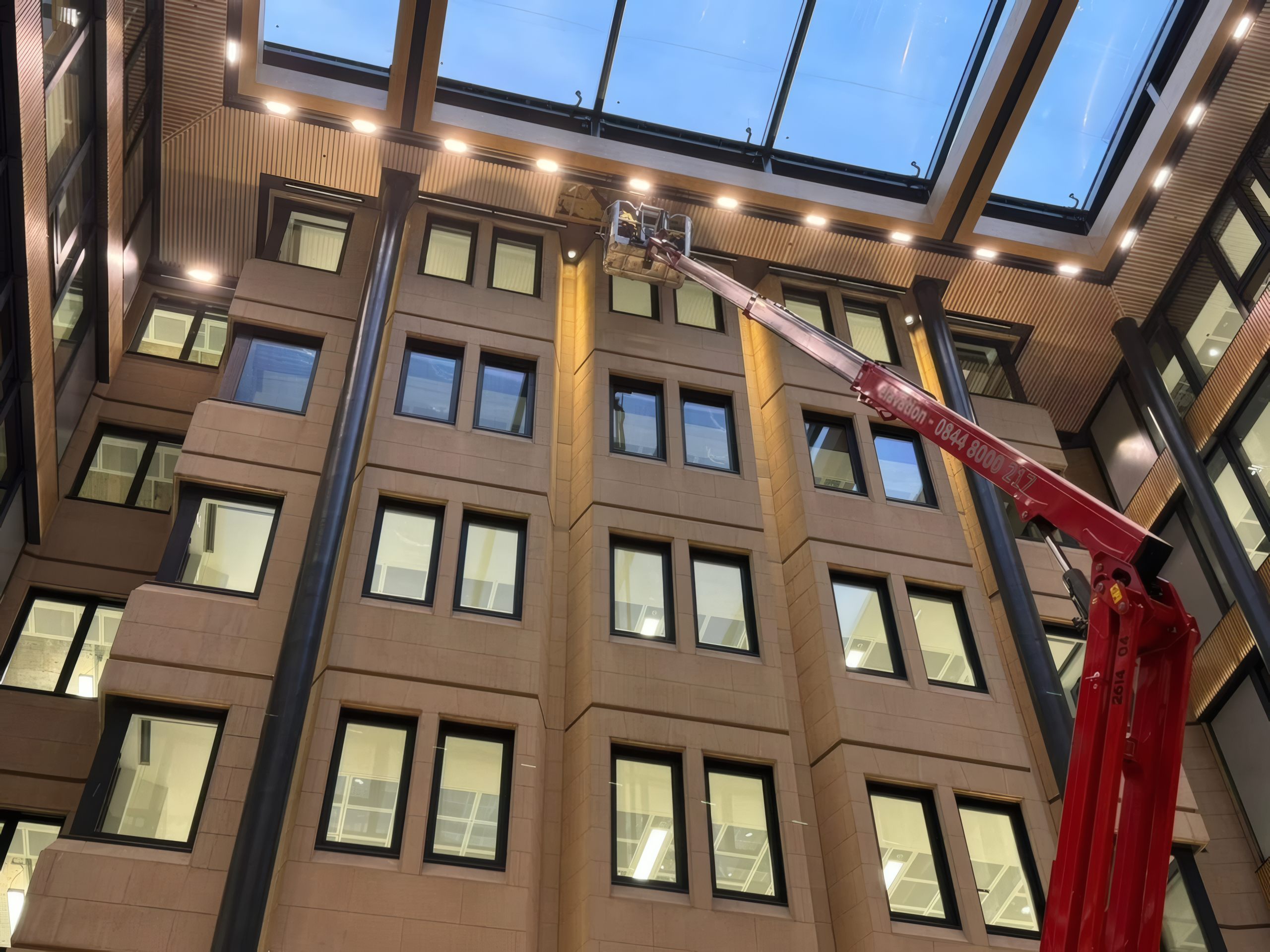 The atrium at 90 Long Acre, London, with its roof glazing lit at dusk.