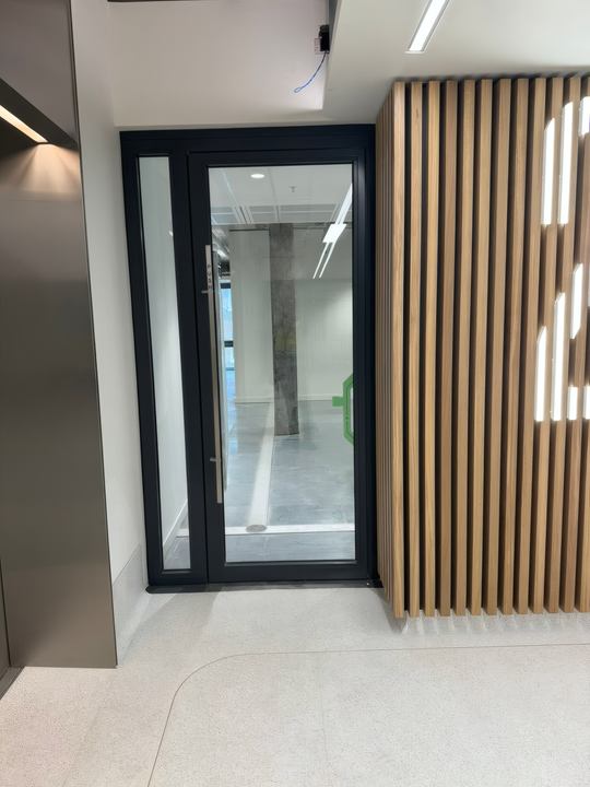 A completed glazed door set against timber-slat wall panelling.